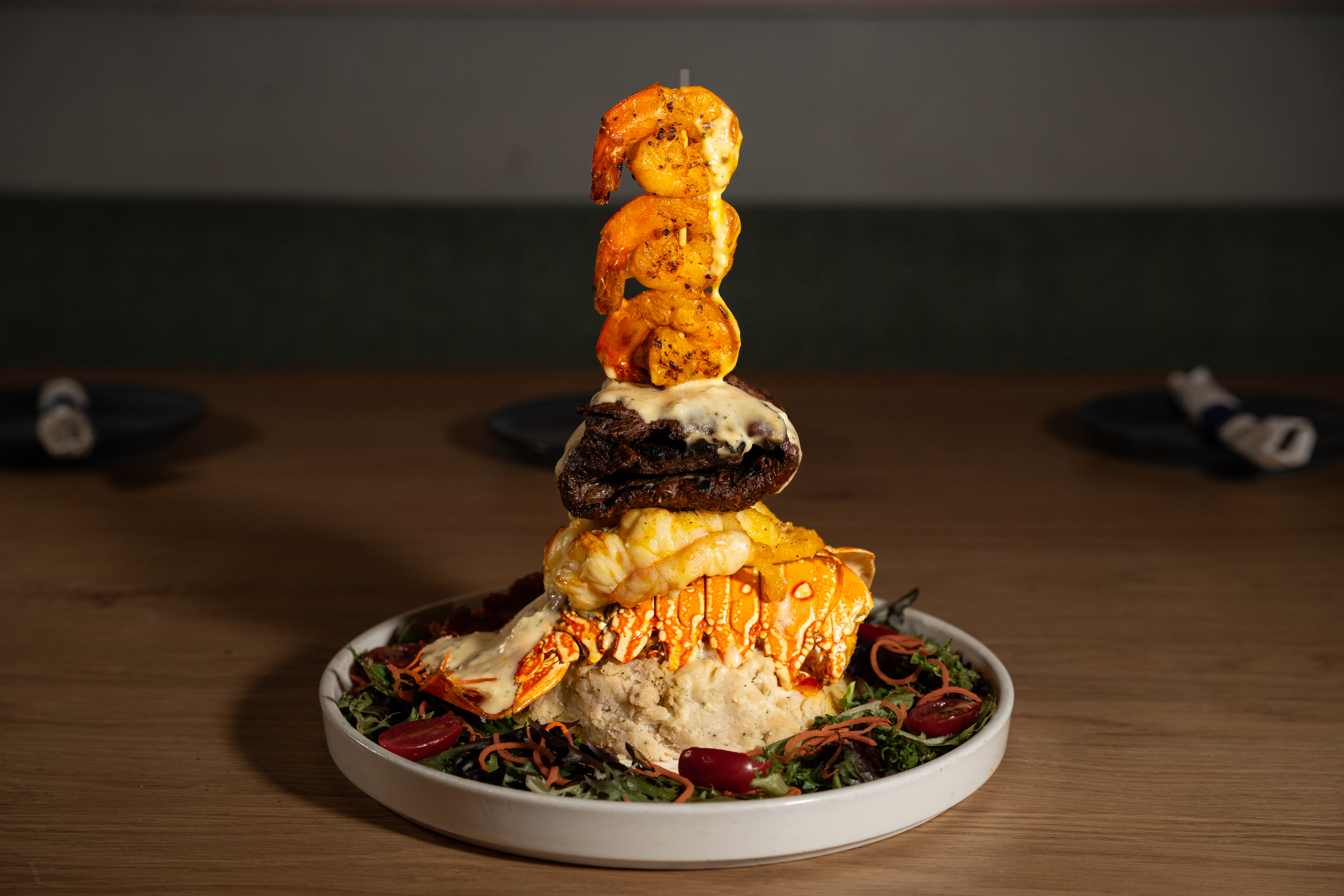 Lobster Trio — 12 oz lobster tail over a root vegetable mash with 12 oz skirt steak and 3 jumbo shrimp in garlic cream sauce.